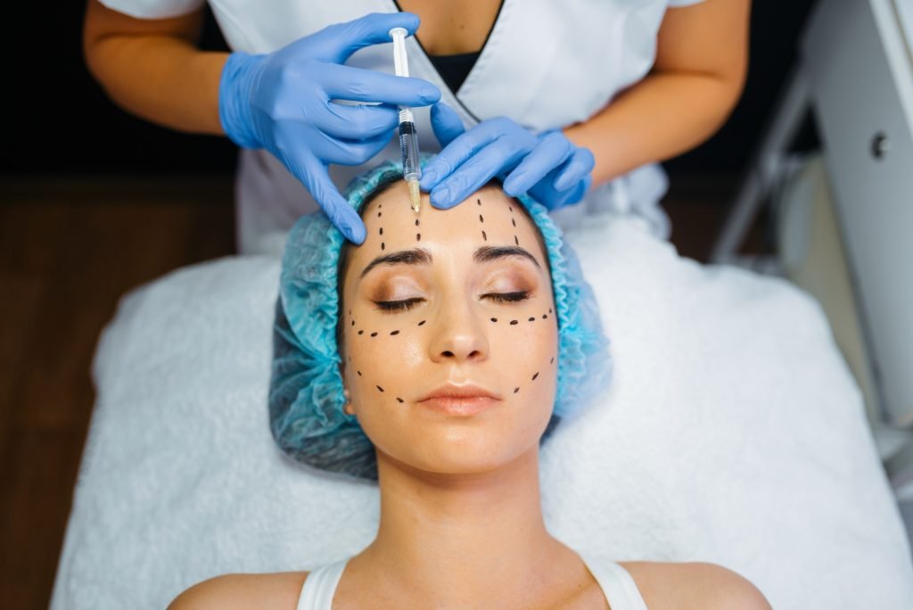 Cosmetician makes botox injection in dotted lines